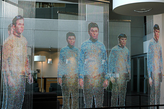 Installation view at Microsoft: Spock, Kirk, and McCoy Beaming-In (in-between), installed in front of an 8' x 12' mirror. Each figure constructed from 25,000+ colored faceted beads and silver bicone beads, monofilament, silver painted wooden dowels
