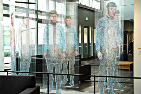 Installation view at Microsoft: Spock, Kirk, and McCoy Beaming-In (in-between), installed in front of an 8' x 12' mirror. Each figure constructed from 25,000+ colored faceted beads and silver bicone beads, monofilament, silver painted wooden dowels